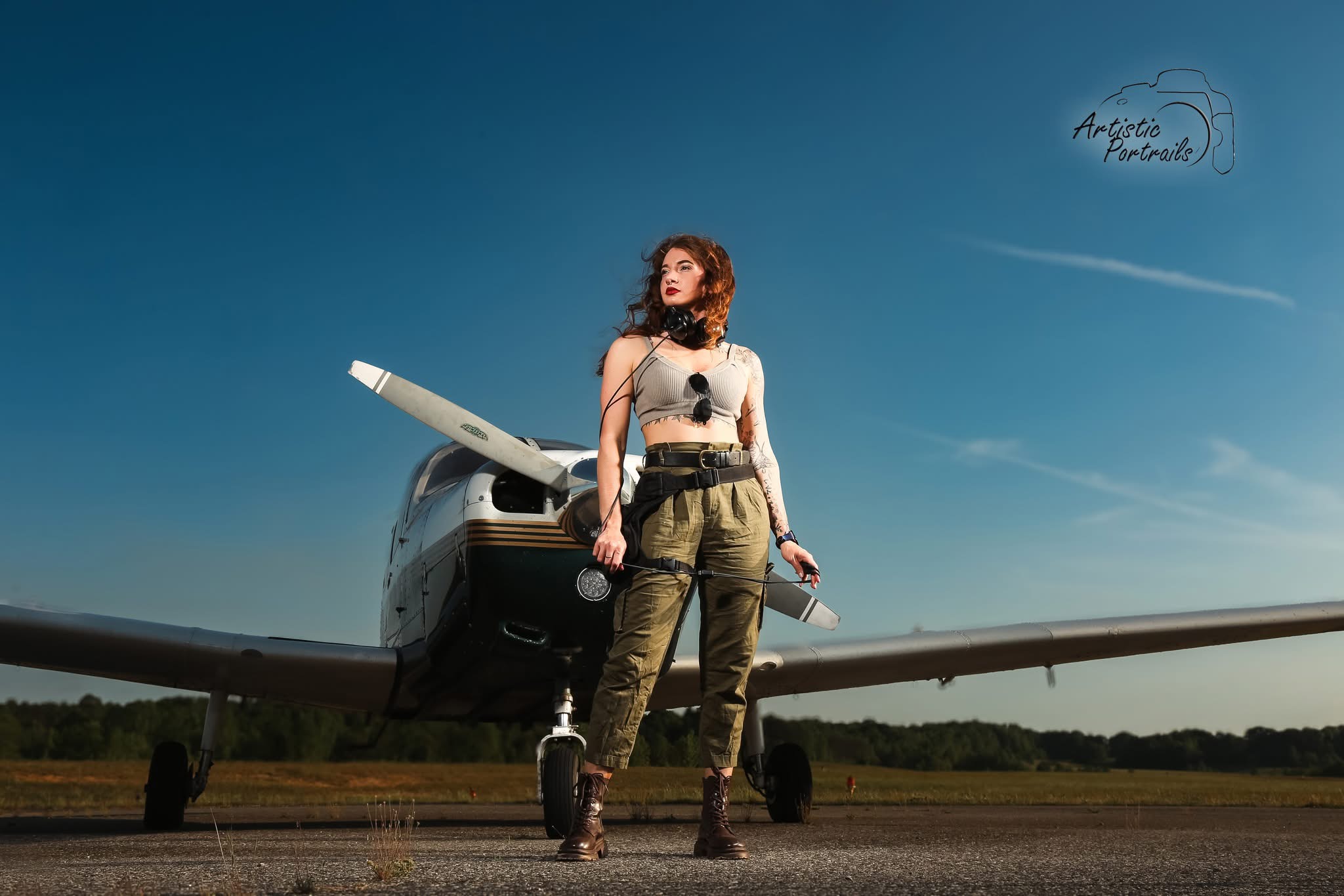 Rachel McFarland standing in front of a single-engine airplane at the airport